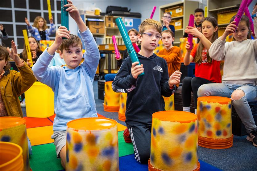Students play drums in music class
